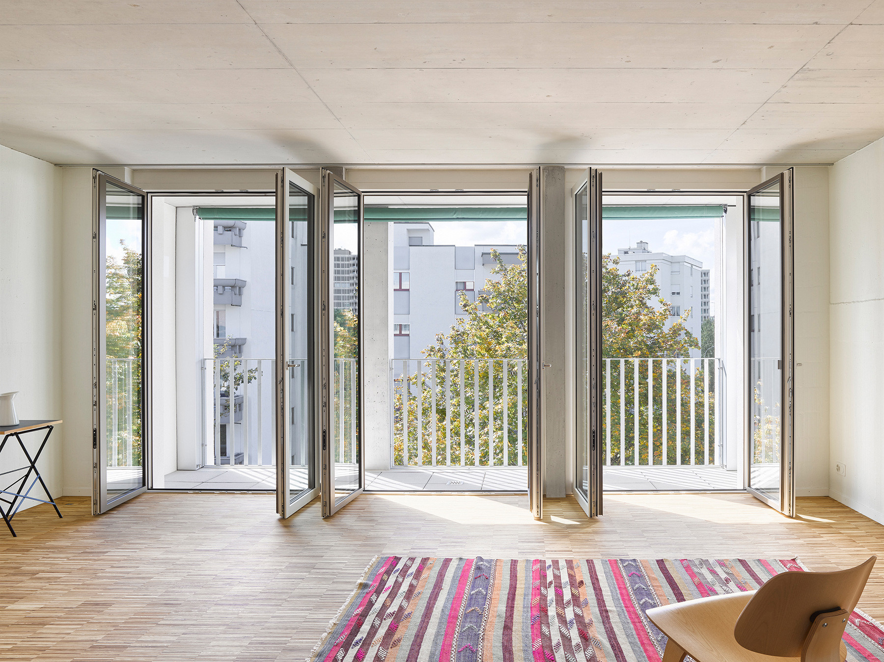Wohnzimmer der 1½-Zimmer-Wohnung mit Zugang zum Balkon und Blick ins Grüne.