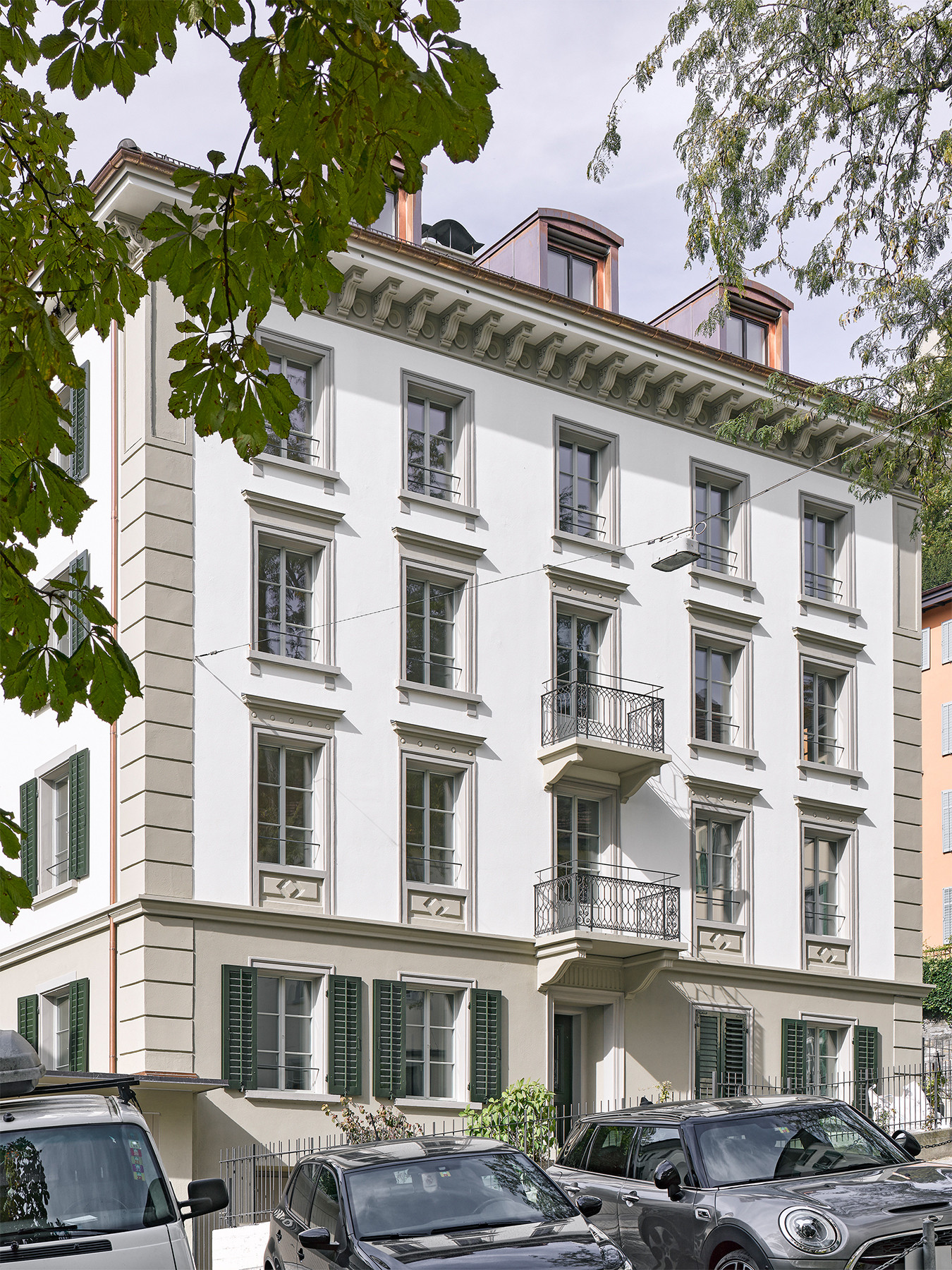 Saniertes Altstadthaus mit hellem Fassadenputz, grauen Steingewänden und Dachgauben aus Kupfer