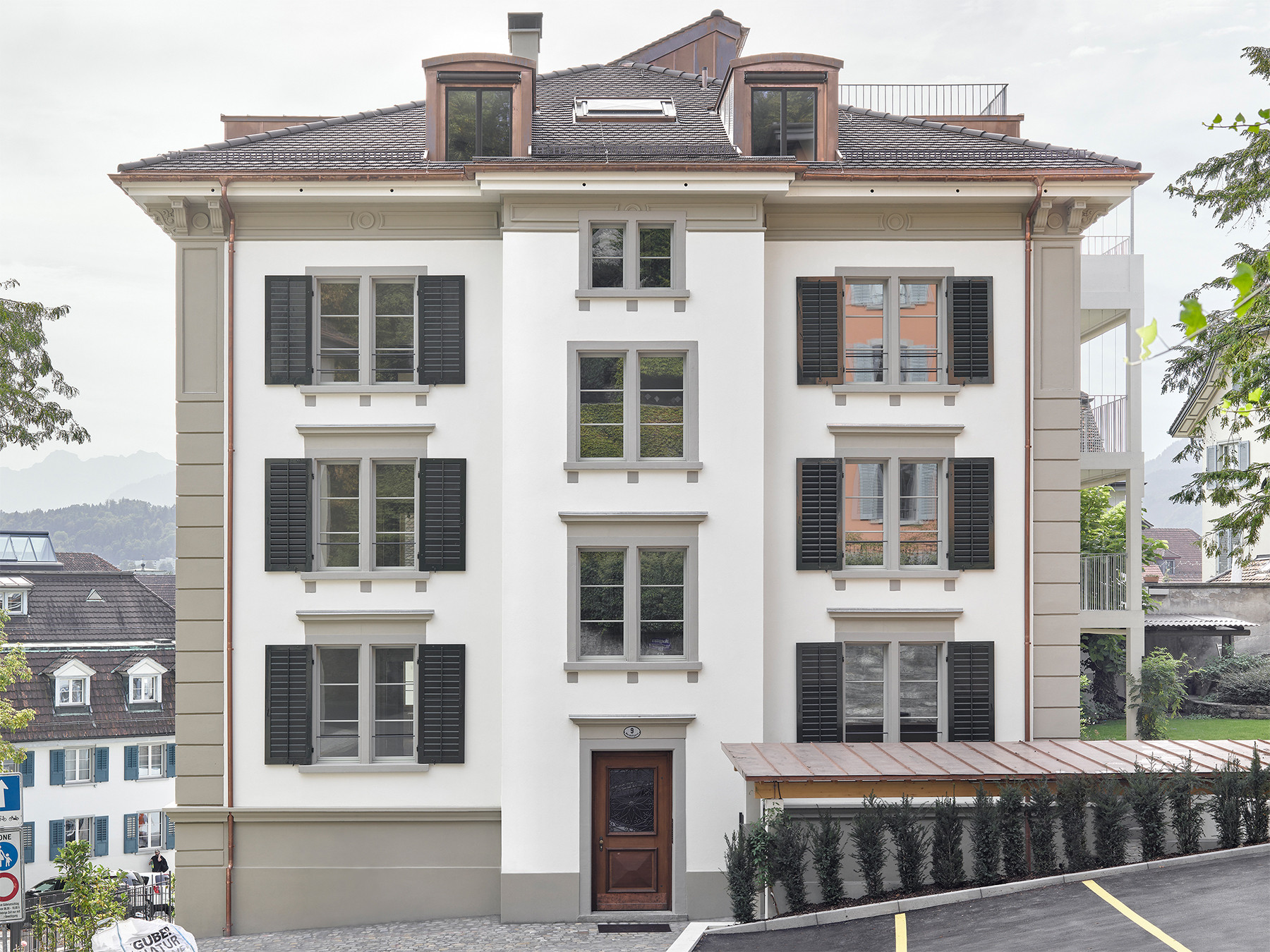 Saniertes Altstadthaus mit grünen Fensterläden, hellem Fassadenputz und grauen Steingewänden
